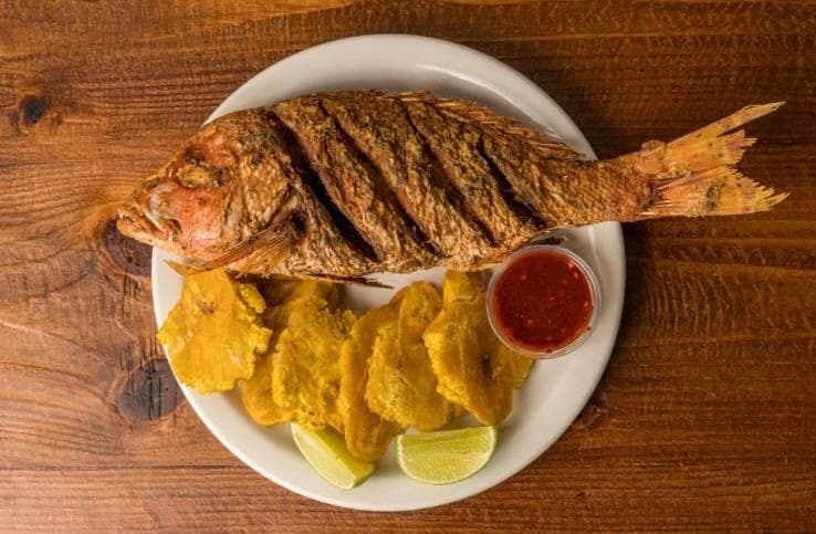 Fried whole fish with tostones and lime