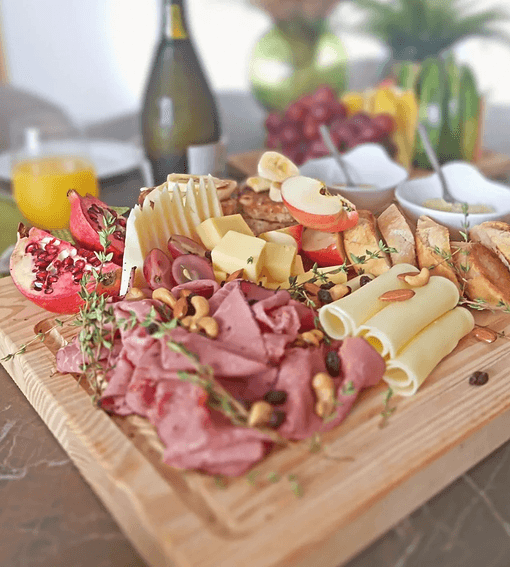 Gourmet brunch board with cured meats, cheese and fresh fruit