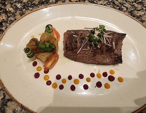 Grilled steak with roasted potatoes and sauce dots