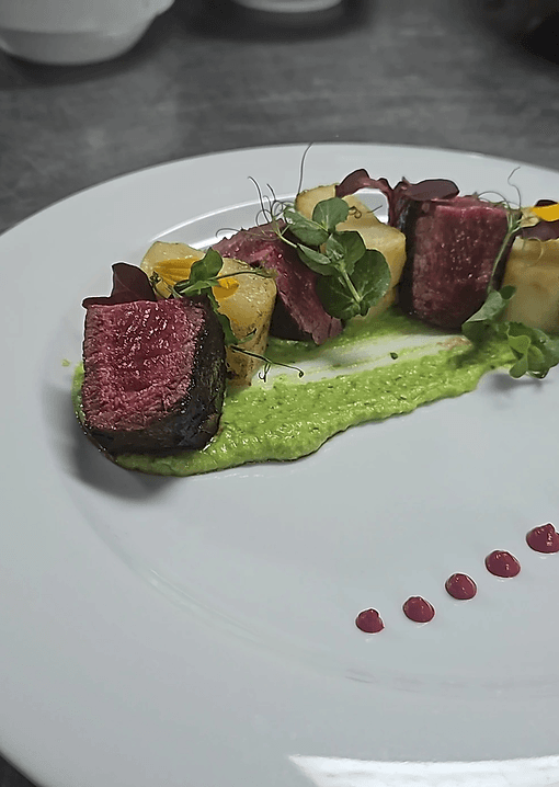 Medium-rare steak slices with herb puree