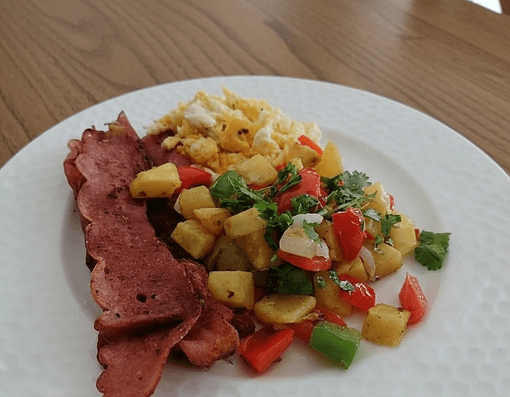 Caribbean breakfast with eggs, plantains, and fresh fruit